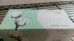 Close-up of a PurCotton rectangular tissue box with cotton blossom artwork on a shelf and product text on the side.