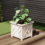 White outdoor lattice planter on a wood deck corner with a green leafy plant inside