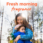 Smiling woman hugging a child outdoors under 'Fresh morning fragrance' headline promoting scent association