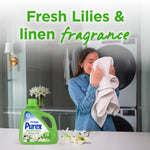 Woman smelling a towel in a laundry room scene with a Purex Natural Elements bottle and lilies, advertising fresh lilies & linen fragrance