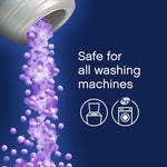 Illustration of purple scent beads pouring from a container with text 'Safe for all washing machines' and washer icons.