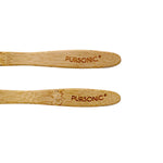 Two bamboo toothbrush handles engraved with the Pursonic logo on a white background