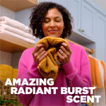 Woman smelling a towel with eyes closed in a laundry room scene and text advertising Radiant Burst scent