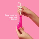 Close-up of hands snapping a white compostable floss pick into a bright pink Radius Kidz reusable handle against a pink background