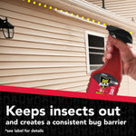 Hand holding a red Raid Max spray bottle applying a dotted protective barrier along the exterior siding of a house