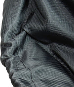 Close-up texture of dark woven fabric with gathered elastic hem, showing material weave and stitching