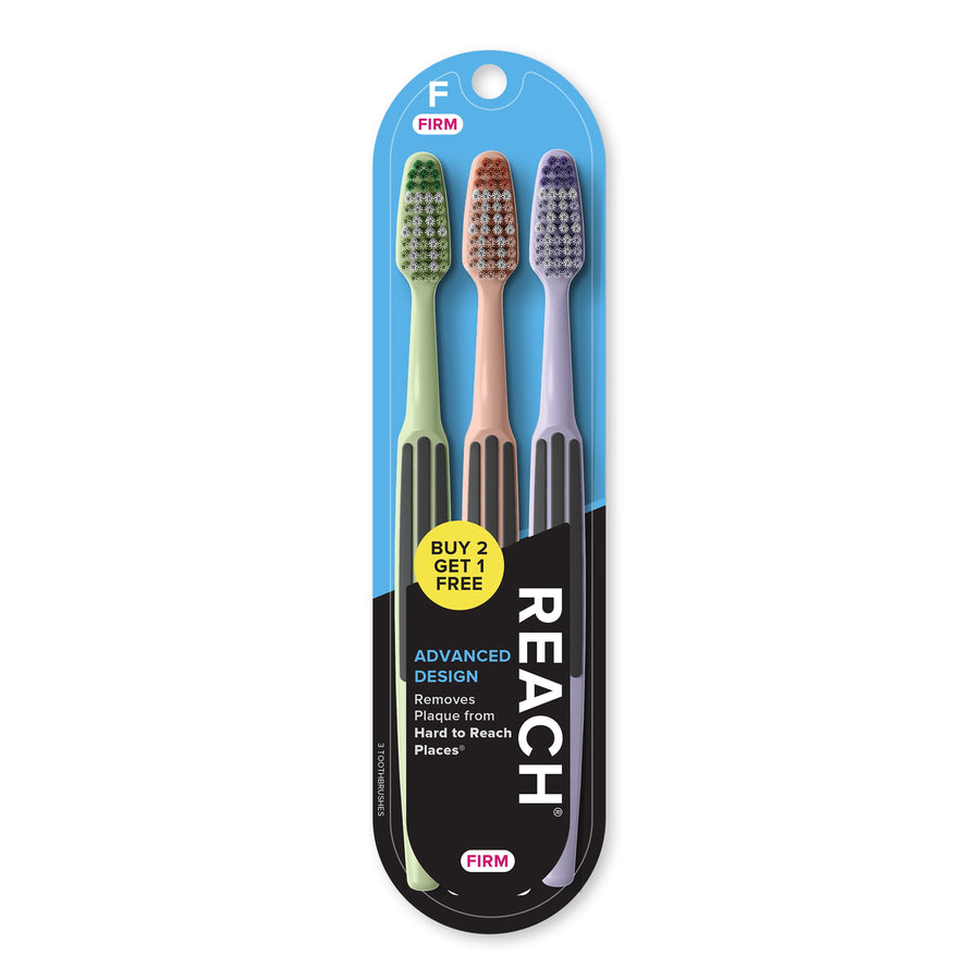 Three REACH toothbrushes in pastel handles packaged on blue blister card with brand logo and promotional sticker