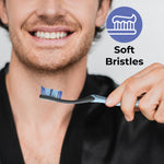 Smiling person holding a Reach toothbrush toward the camera with a soft-bristles icon and text indicating "Soft Bristles" to the side.