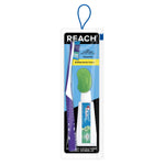 Reach travel dental kit in clear blister pack showing a purple toothbrush, small toothpaste tube and green antibacterial cover on blue backing