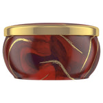 Side profile of a red and gold decorative candle tin with a fitted gold lid, no label visible