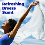 Lifestyle image of a smiling person holding a white sheet outdoors under blue sky with text reading ‘Refreshing Breeze Scent’
