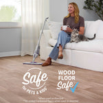 Woman seated on couch with Rejuvenate spray mop on wood floor and icons stating safe for pets, kids, and wood floors