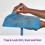 Hands lifting a used blue Rejuvenate microfiber pad on a mop head to reveal trapped dust, hair, and debris.