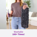 Person holding a dark chenille Rejuvenate PowerMax sweep pad next to a mop handle in a living room setting
