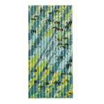 Single corrugated FlyPad trap covered with stuck flies on a blue-green patterned adhesive surface