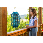 Hanging blue Rescue! Fly Trapstik on a porch railing with a blurred person and greenery in the background