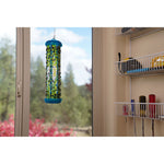 RESCUE! TrapStik hanging in front of a window with many trapped flies visible on the adhesive surface