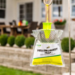 Hanging RESCUE! Yellowjacket Trap outdoors with green funnel top and clear bag, blurred patio background