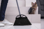 Reynera broom head on floor at the base of stairs with a small dog visible on the steps in the background.