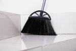 Reynera broom head positioned in a tiled corner sweeping surface with reflection on glossy floor.