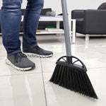 Reynera angled broom being used on a glossy tiled floor, showing broom head, handle and a person's shoes.