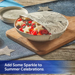 Bowl of mixed berries partially covered with embossed aluminum foil showing a fireworks pattern on a wooden board