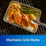 Aluminum disposable pan on grill holding grilled chicken, asparagus and potatoes with tongs, caption 'Maintains Grill Marks'