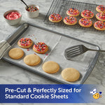 Baking sheet lined with Reynolds Kitchens pre-cut parchment showing plain and frosted cookies and SmartGrid pattern