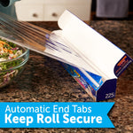 open reynolds kitchens plastic wrap box on a kitchen counter with film pulled out and a blue banner reading automatic end tabs keep roll secure