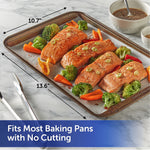Baking sheet lined with Reynolds parchment holding cooked salmon and vegetables with arrows showing 10.7" x 13.6" dimensions.