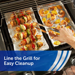 Grill racks lined with aluminum foil sheets holding skewers and shrimp, demonstrating lining the grill for easy cleanup