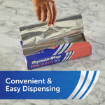 Hand pulling a pre-cut sheet from an open Reynolds Wrap pop-up foil sheets box on a marble surface