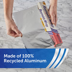 Hands pulling a sheet of Reynolds Wrap recycled aluminum foil from its box on a marble countertop with product message