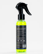 Rear view of Riptide Armory optic glass cleaner bottle showing the back label, instructions and neon green liquid.