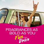 Two women enjoying a road trip in a vintage van, used as a fragrance lifestyle image with a magenta promotional banner.