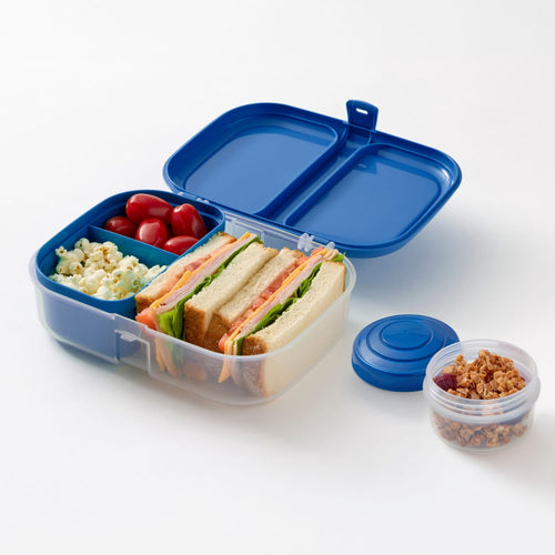 Blue Rubbermaid bento lunchbox open showing sandwich, popcorn, tomatoes and mini jar