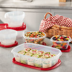 Assortment of Rubbermaid TakeAlongs containers with red lids on a kitchen counter, filled with wraps, salad and fruit