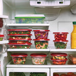 Refrigerator shelves stocked with clear Rubbermaid containers with red lids holding salads, fruit and prepared meals