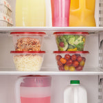 Four stacked Rubbermaid TakeAlongs containers with red lids stored inside a refrigerator with food inside