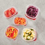 Five clear Rubbermaid TakeAlongs containers with red lids shown from above, each holding different cut vegetables