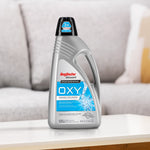 Rug Doctor Bissell OXY cleaner bottle staged on a table in front of a blurred sofa, blue label visible