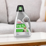 Rug Doctor by BISSELL PET cleaner bottle placed on a white table with blurred couch background