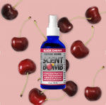 Blue Scent Bomb Black Cherry spray bottle over a pink background patterned with whole cherries