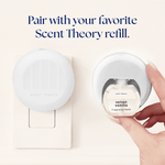 White Scent Theory diffuser plugged in beside a hand inserting a velvet vanilla fragrance refill bottle