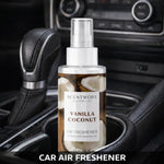 Scentworx Vanilla Coconut spray bottle placed in a car cupholder as a lifestyle shot with dashboard controls visible behind it.