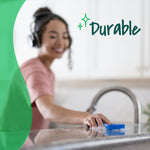 Person using a blue Scotch-Brite sponge to wipe a countertop with the word durable overlaid