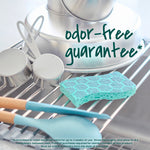 Teal hex-pattern scrub sponge resting on a drying rack near cookware with overlay text reading "odor-free guarantee."