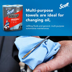blue shop towel wiping an engine dipstick; inset shows scott shop original packaging with two rolls on a blue background