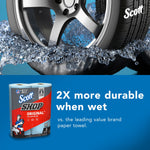 marketing graphic with a car wheel splashing through water and a small image of a scott shop towels two‑roll pack on a blue background