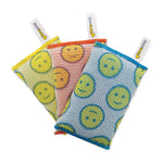 Three patterned scrub cloths with smiley-face motifs and ScrubDaddy tags fanned out on white background